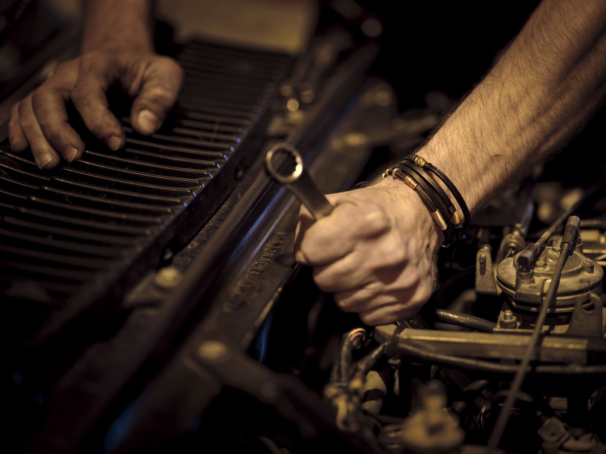Mecânico apertando peça do motor com chave